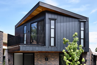 Идея дизайна: двухэтажный, черный, большой частный загородный дом в современном стиле с облицовкой из металла, плоской крышей и металлической крышей