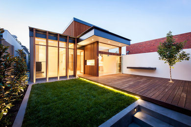 This is an example of a medium sized contemporary two floor house exterior in Melbourne with wood cladding.