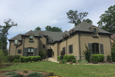 Large traditional beige two-story stucco house exterior idea in Atlanta with a hip roof and a shingle roof