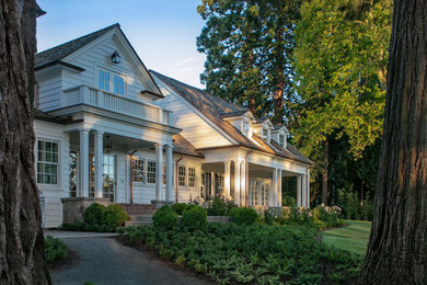 Example of a large classic white three-story wood exterior home design in Portland with a shingle roof
