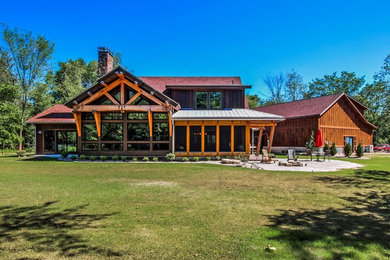 Mid-sized mountain style brown two-story wood exterior home photo in Grand Rapids with a mixed material roof