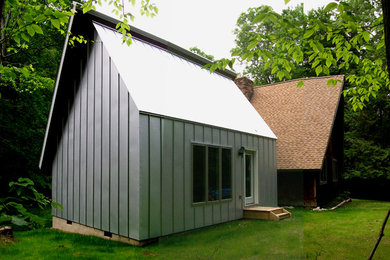 This is an example of a medium sized and brown contemporary two floor house exterior in New York with metal cladding.