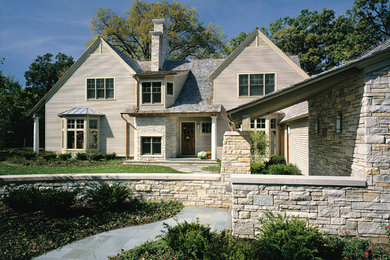 Imagen de fachada beige de estilo americano grande de dos plantas con revestimiento de madera y tejado a dos aguas