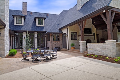 Large elegant beige two-story stone house exterior photo in St Louis with a shingle roof