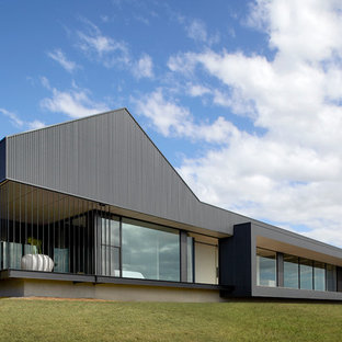Contemporary one-storey black house exterior in Other with a flat roof.