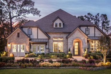 Example of a large classic beige two-story mixed siding exterior home design in Houston with a hip roof