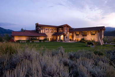 Example of a large tuscan beige two-story mixed siding gable roof design in Denver