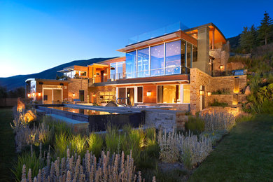 This is an example of a large and beige contemporary detached house in Denver with three floors, mixed cladding and a flat roof.