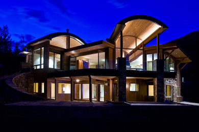 Foto de fachada marrón contemporánea de tamaño medio de dos plantas con revestimientos combinados y tejado plano