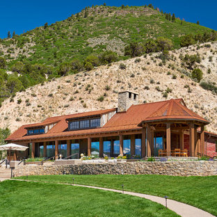 Ispirazione per la facciata di una casa unifamiliare grande rossa rustica con rivestimento in legno, copertura in metallo o lamiera e tetto a capanna