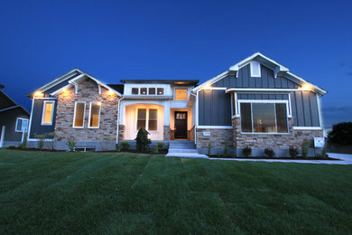 Imagen de fachada de casa azul de estilo americano de tamaño medio de dos plantas con revestimientos combinados, tejado a dos aguas y tejado de teja de madera