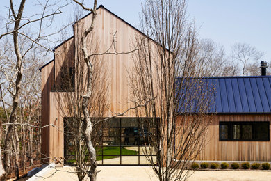 Modelo de fachada de casa moderna extra grande de dos plantas con revestimiento de madera, tejado a dos aguas y tejado de metal