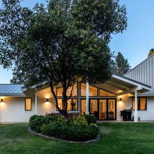 Mid-century modern white two-story exterior home idea in Sacramento with a metal roof