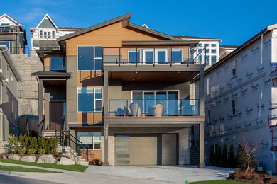 Example of a large minimalist brown three-story house exterior design in Vancouver