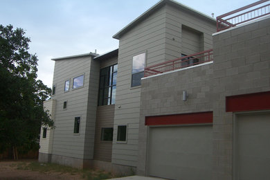 Aménagement d'une petite façade de maison rétro à un étage avec un revêtement mixte et un toit plat.