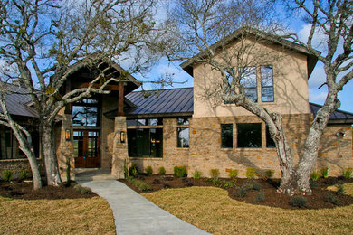 Inspiration for a large and brown contemporary two floor house exterior in Austin with stone cladding.