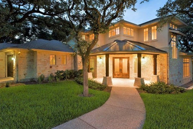 Transitional beige two-story stone exterior home photo in Austin with a hip roof