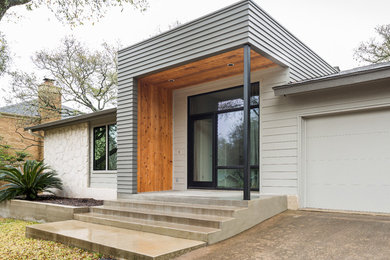 Inspiration for a transitional gray one-story concrete fiberboard exterior home remodel in Austin with a hip roof