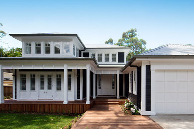 This is an example of a large and black beach style two floor detached house in Sydney with mixed cladding, a hip roof and a metal roof.