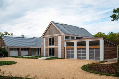 Cette image montre une grande façade de maison grise design en bois à un étage.