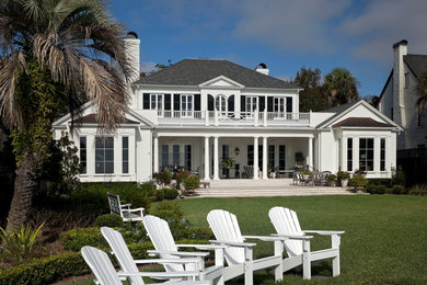 Пример оригинального дизайна: большой, двухэтажный, кирпичный, белый дом в классическом стиле с двускатной крышей