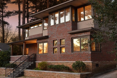 Inspiration for a large contemporary two-story brick house exterior remodel in Atlanta with a shingle roof