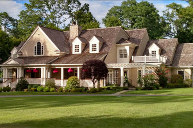 Example of a mid-sized classic beige two-story wood exterior home design in New York with a shingle roof