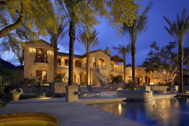 Design ideas for an expansive and beige mediterranean two floor house exterior in Phoenix with stone cladding.