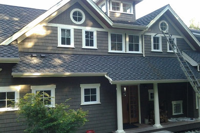 Example of an arts and crafts gray two-story wood exterior home design in Seattle