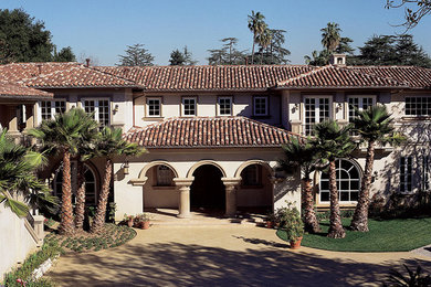 Diseño de fachada de casa beige mediterránea grande de dos plantas con tejado a cuatro aguas y tejado de teja de barro