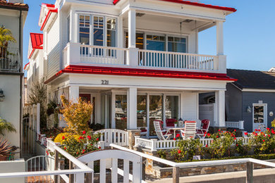 Inspiration for a coastal white three-story exterior home remodel in Orange County with a red roof