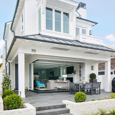 Large coastal white two-story wood exterior home idea in Orange County with a hip roof