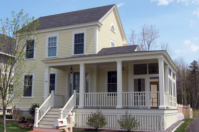 Example of a mid-sized classic yellow two-story gable roof design in Portland Maine