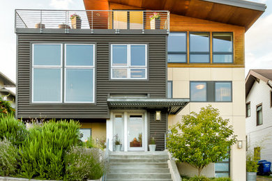 Aménagement d'une façade de maison beige moderne de taille moyenne et à deux étages et plus avec un revêtement mixte et un toit en appentis.