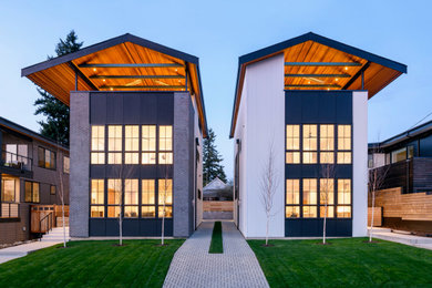 Imagen de fachada de casa bifamiliar multicolor contemporánea de tamaño medio con revestimientos combinados y tejado a dos aguas