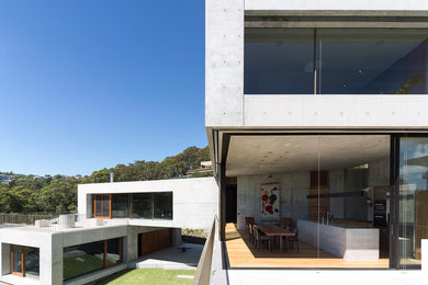 Свежая идея для дизайна: трехэтажный, серый частный загородный дом с облицовкой из бетона и плоской крышей - отличное фото интерьера