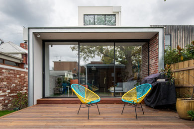 Imagen de fachada de casa multicolor contemporánea pequeña de dos plantas con revestimientos combinados, tejado plano y tejado de metal