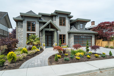 Ejemplo de fachada de casa gris de estilo americano grande de dos plantas con revestimientos combinados