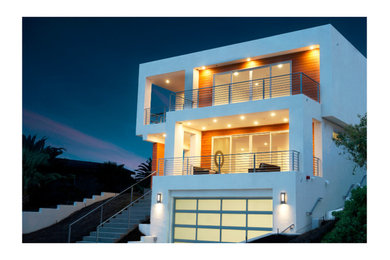 Diseño de fachada minimalista grande de tres plantas con revestimiento de estuco y tejado plano