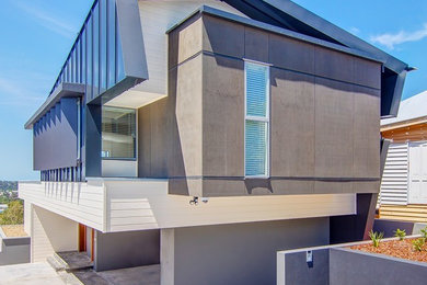 Foto della facciata di una casa grigia contemporanea a due piani con rivestimento in cemento