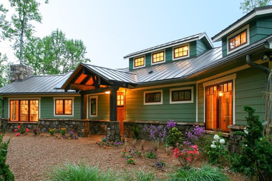 Example of a mid-sized classic green two-story mixed siding exterior home design in Other with a metal roof