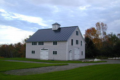 Large and gey traditional two floor house exterior in Portland Maine with wood cladding and a pitched roof.