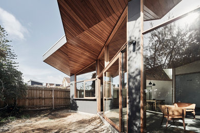 Mittelgroßes, Einstöckiges Modernes Einfamilienhaus mit Faserzement-Fassade, grauer Fassadenfarbe, Flachdach und Blechdach in Melbourne