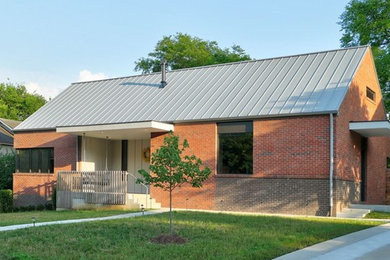 Inspiration for a modern red one-story brick exterior home remodel in Nashville with a metal roof