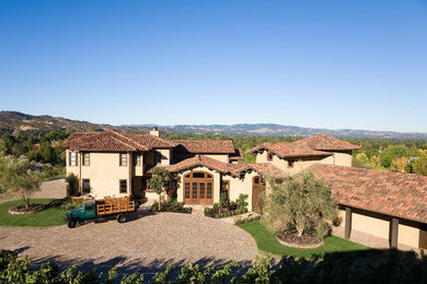 Example of a huge tuscan beige one-story adobe exterior home design in San Francisco