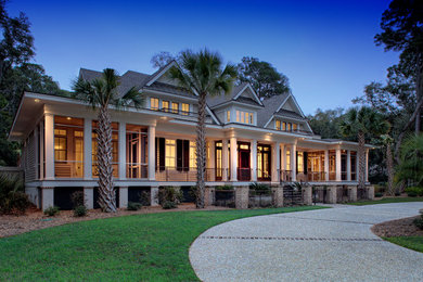 Inspiration for a large tropical beige two-story gable roof remodel in Charleston