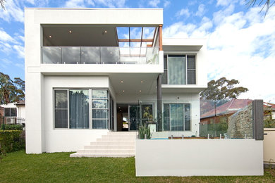 Ejemplo de fachada blanca actual grande de dos plantas con revestimiento de ladrillo y tejado plano