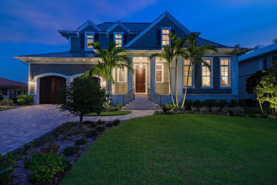 Example of a large transitional green two-story exterior home design in Miami