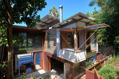 Immagine della villa tropicale a due piani con rivestimenti misti