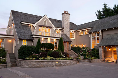 Large traditional gray two-story stucco house exterior idea in Vancouver with a shingle roof